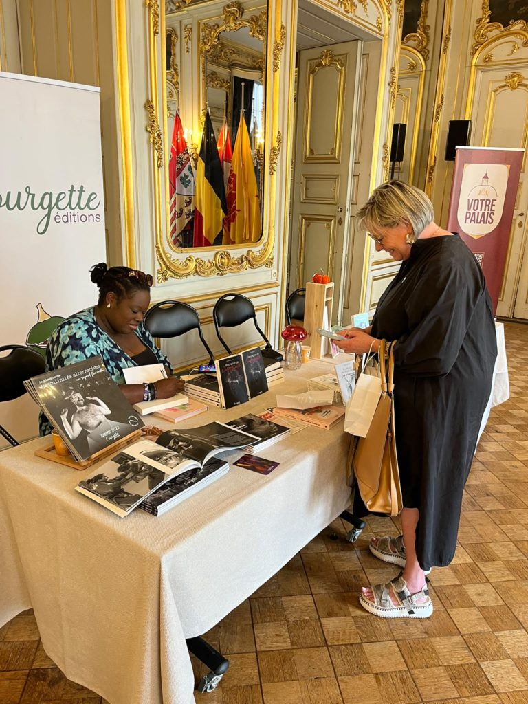 photo du stand de courgette éditions au fêtes de wallonie à liège avec sarah mussenge en dédicace et une cliente